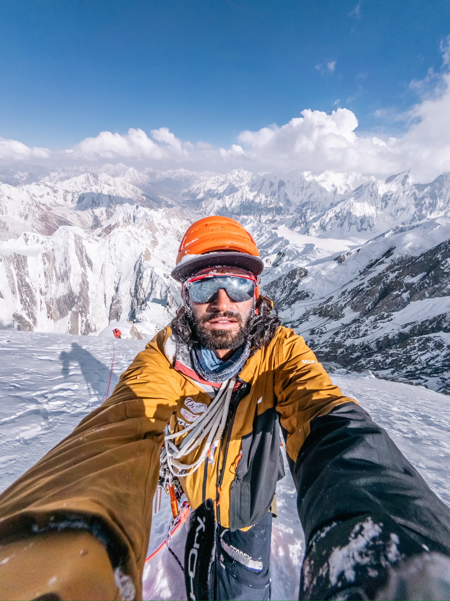 Mueez on a high alpine ridge overlooking a panorama of snow peaks