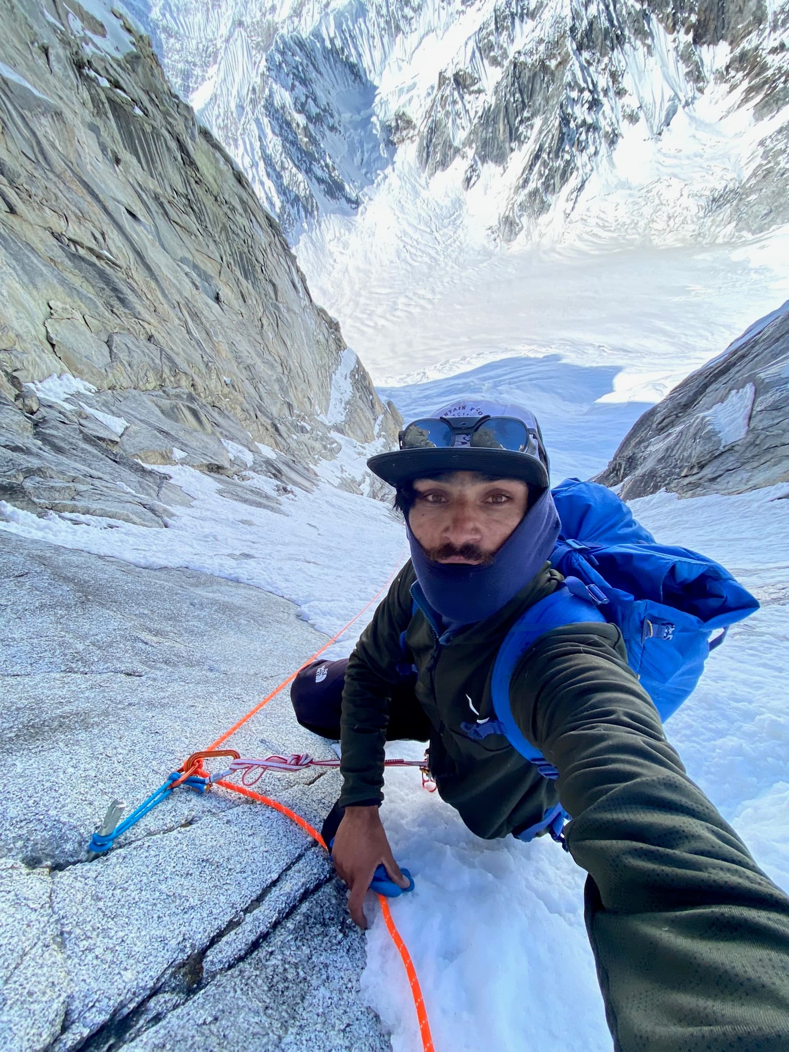 Looking down a steep snow couloir during a high-altitude climb
