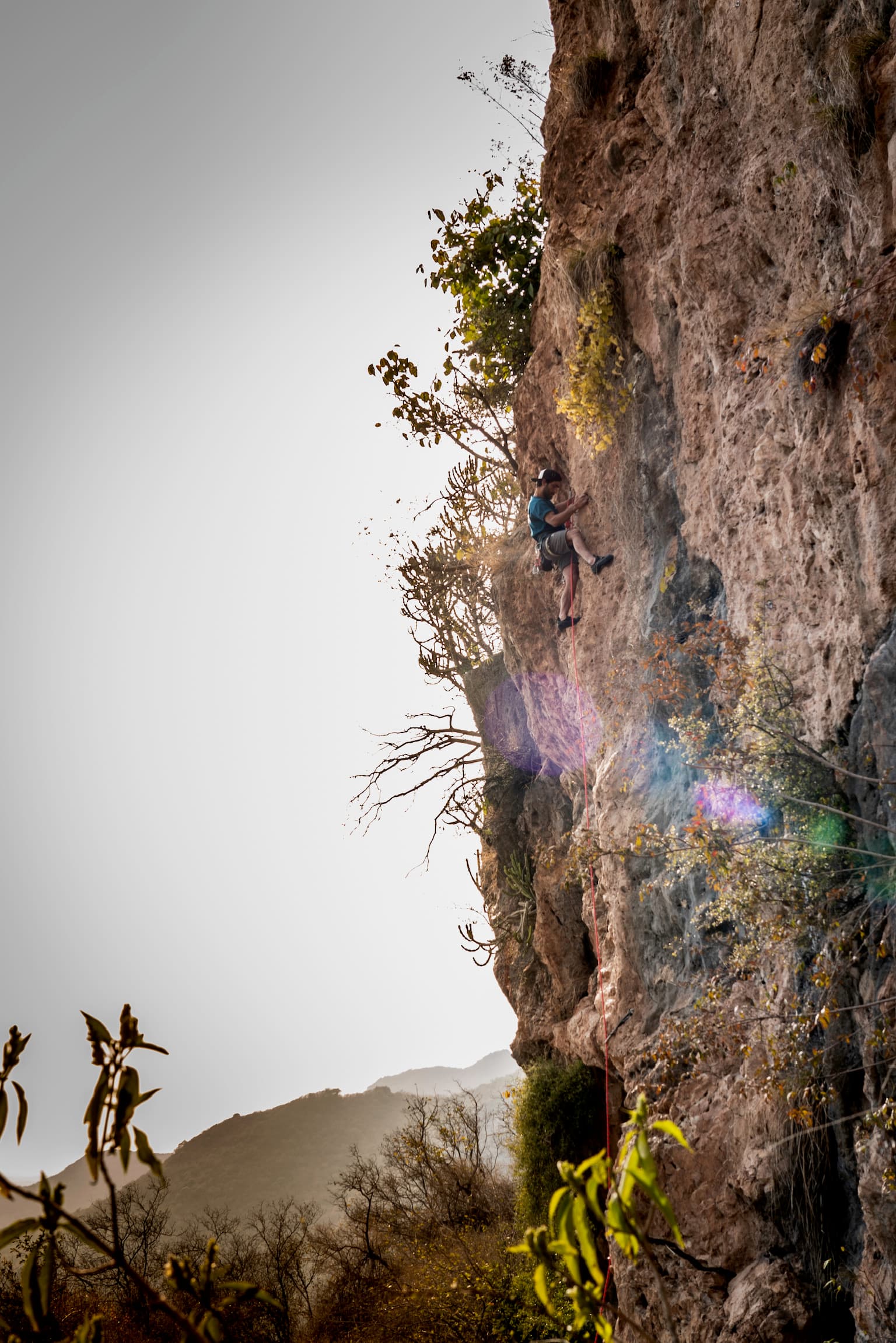 Low-angle climb on a sunlit cliff with valley haze below