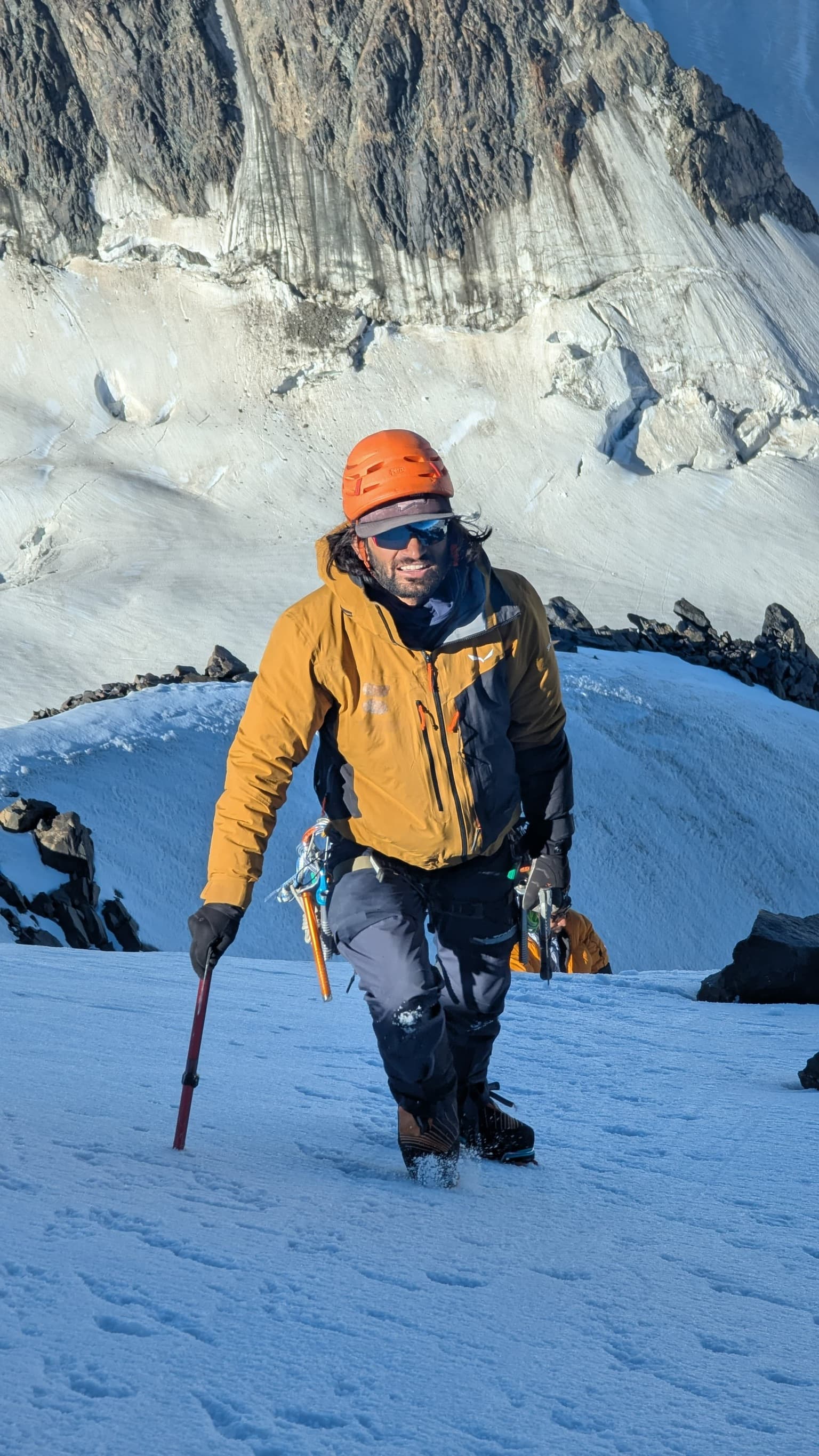 Ascending a steep snow slope with crampons and trekking pole