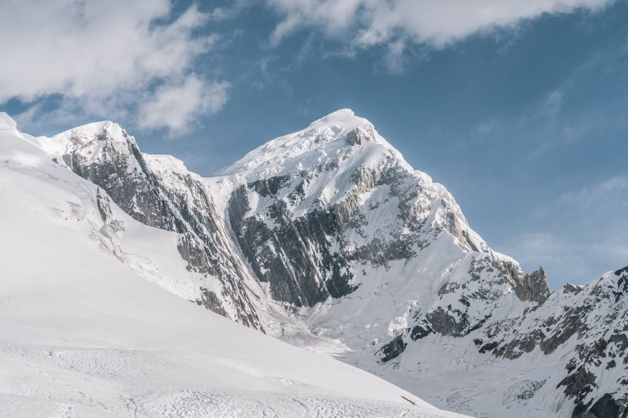 Snow-covered peak rising into a clear alpine sky