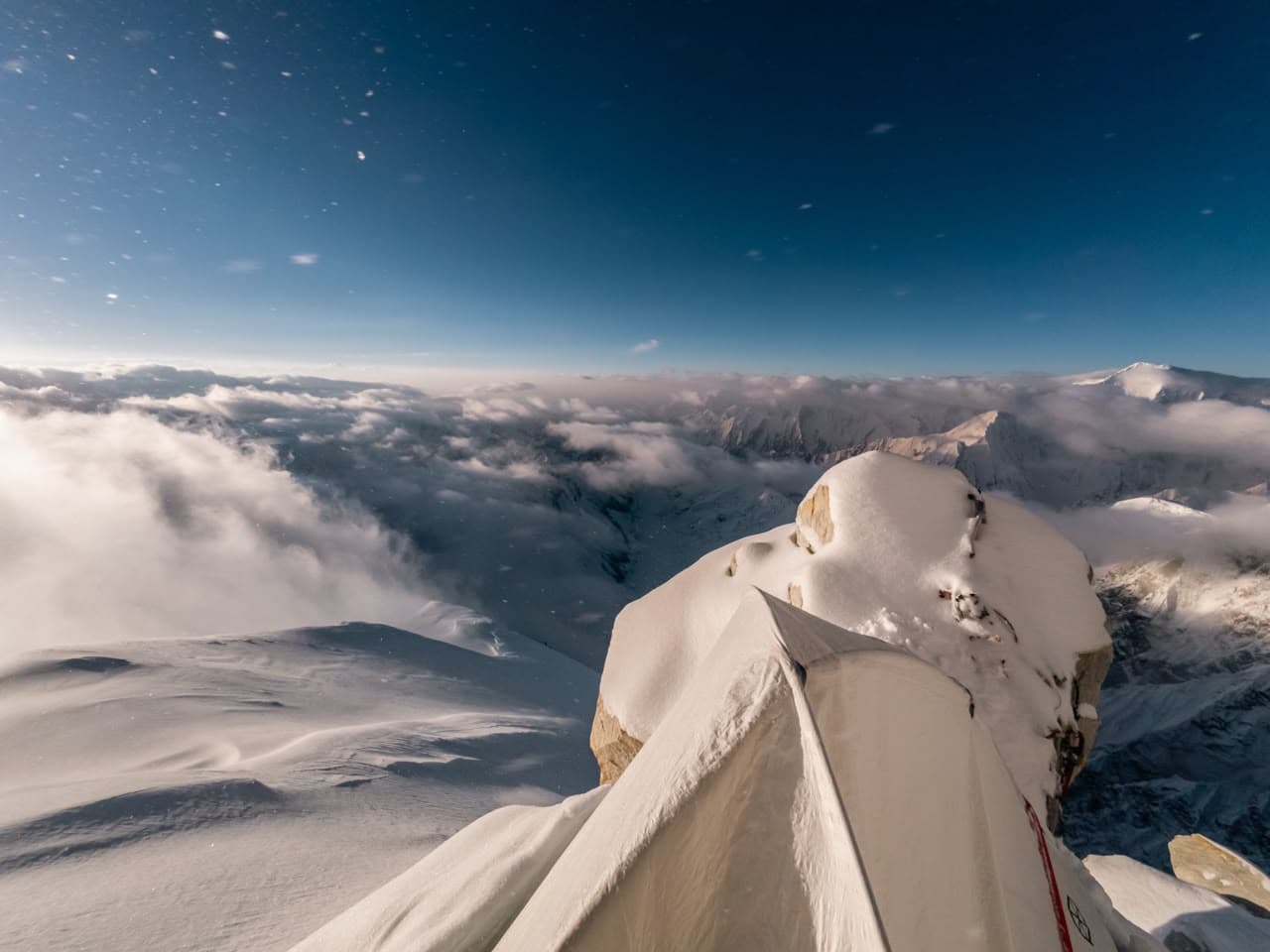 High camp tent on a ridge above a sea of clouds in the Karakoram